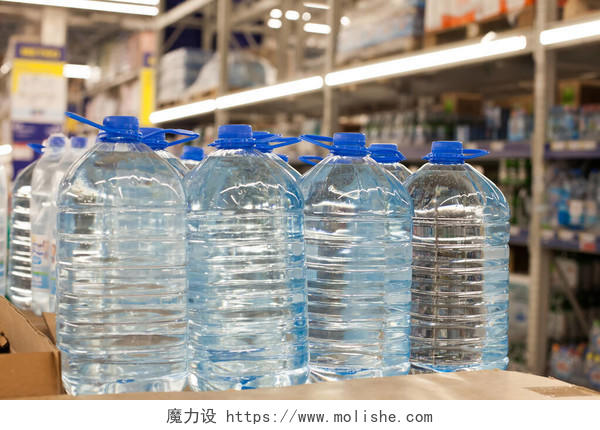 超市里装有蓝色瓶盖的塑料瓶上面有干净的饮用水用塑料包装